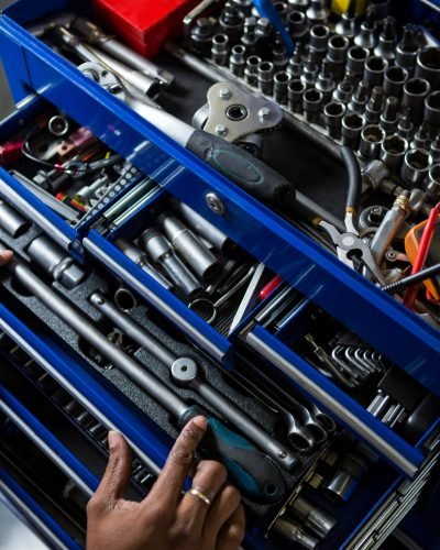 Mechanic selecting work tool from toolbox at repair garage